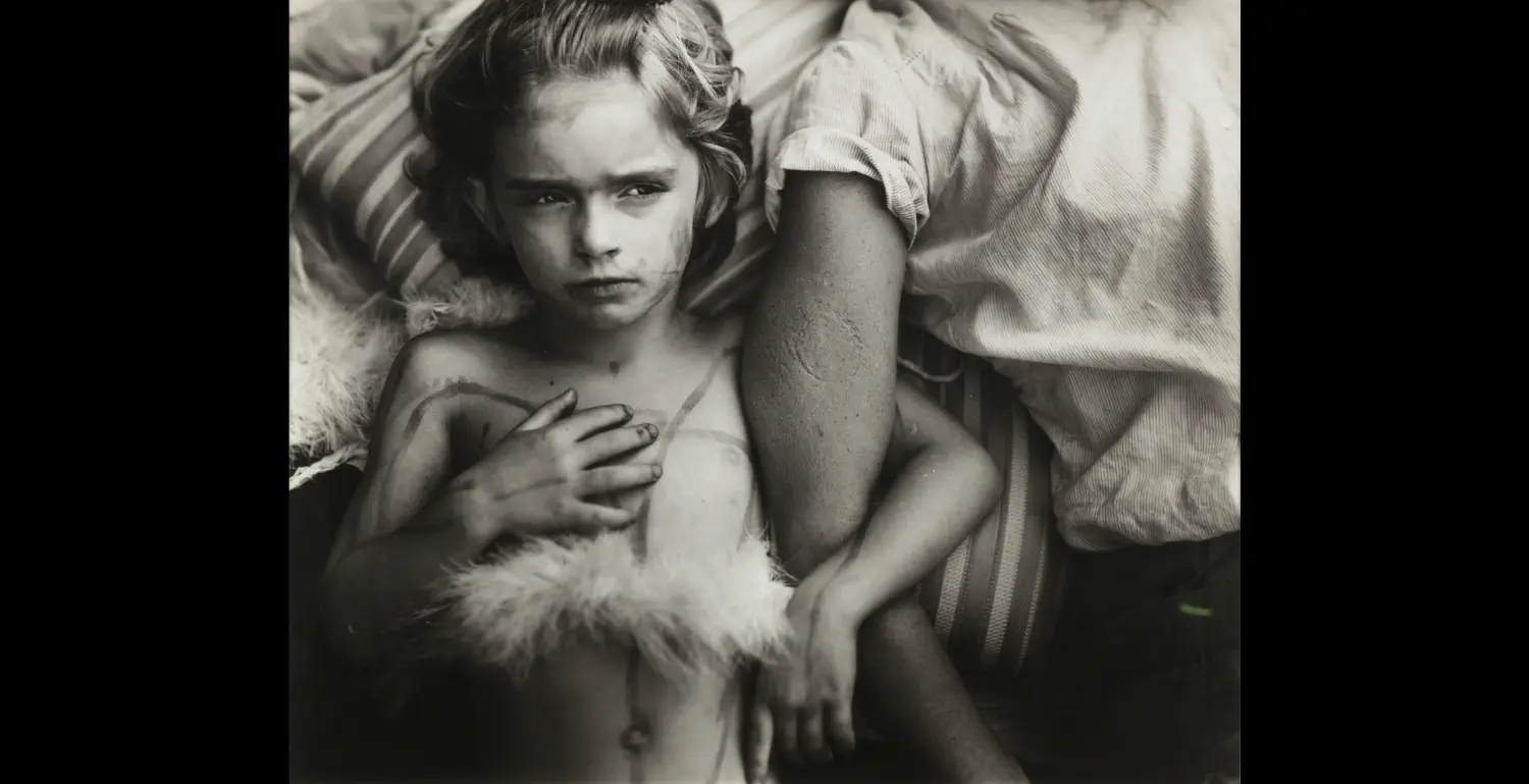 Ein Bild aus der Serie Immediate Family von Sally Mann, das ein Kind mit Süßigkeiten-Zigaretten zeigt.
