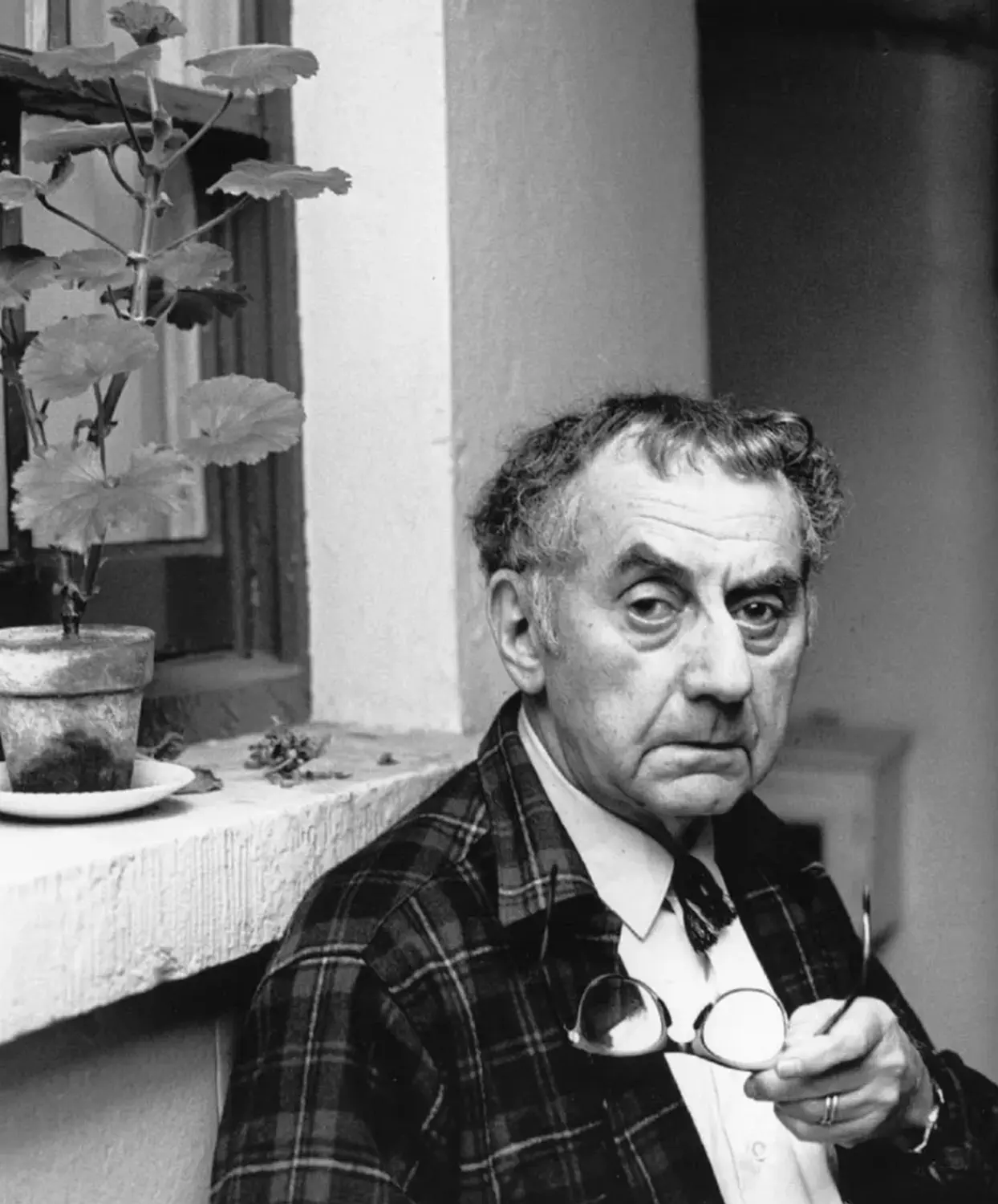 A black and white portrait of the artist Man Ray.
