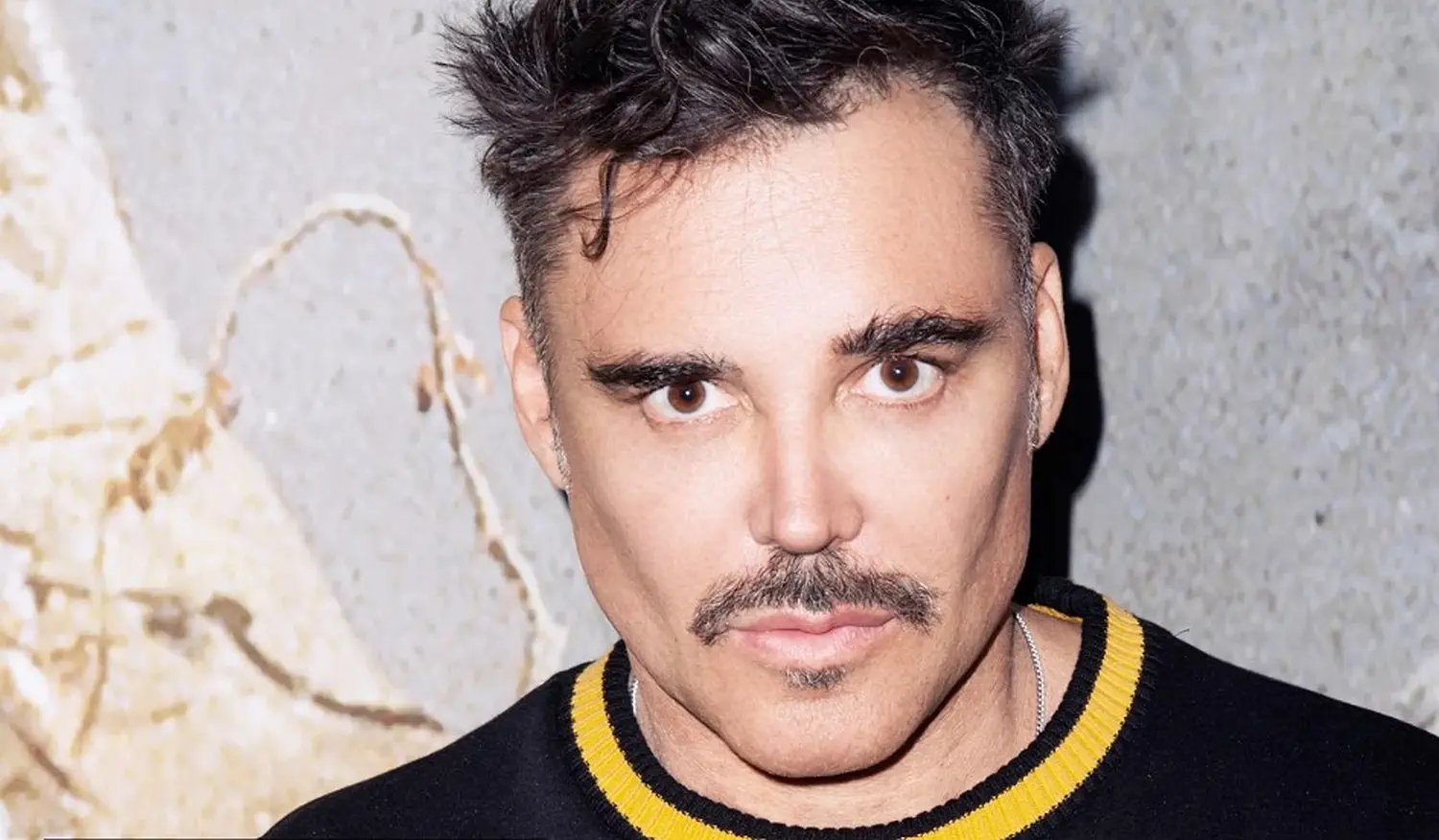 A portrait of photographer David LaChapelle in a colorful setting.