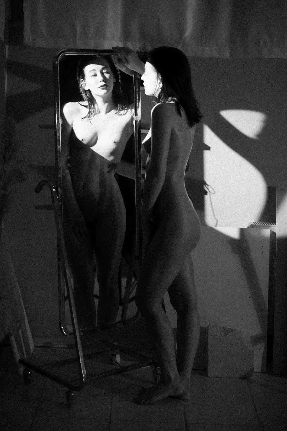 Eine Fotografie von Burak Bulut Yıldırım, die ein nacktes Modell und ihr Spiegelbild zeigt.