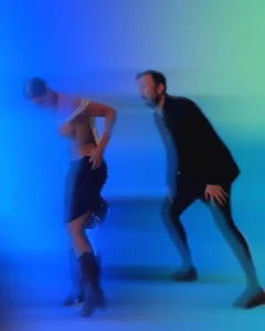 Two people posing in a blue and green blurred studio scene
