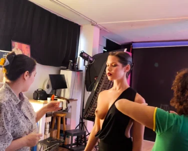 Fashion model being adjusted by stylists during a photo shoot