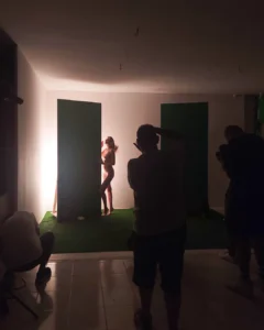 Nude model posing in a studio while photographers take pictures