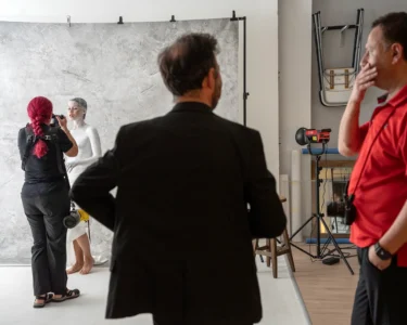 Photographer taking a portrait of a painted model in a studio