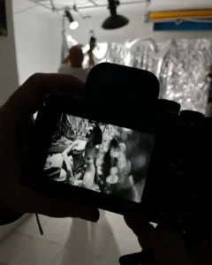 Camera screen showing a black-and-white portrait of a nude woman reclining outdoors